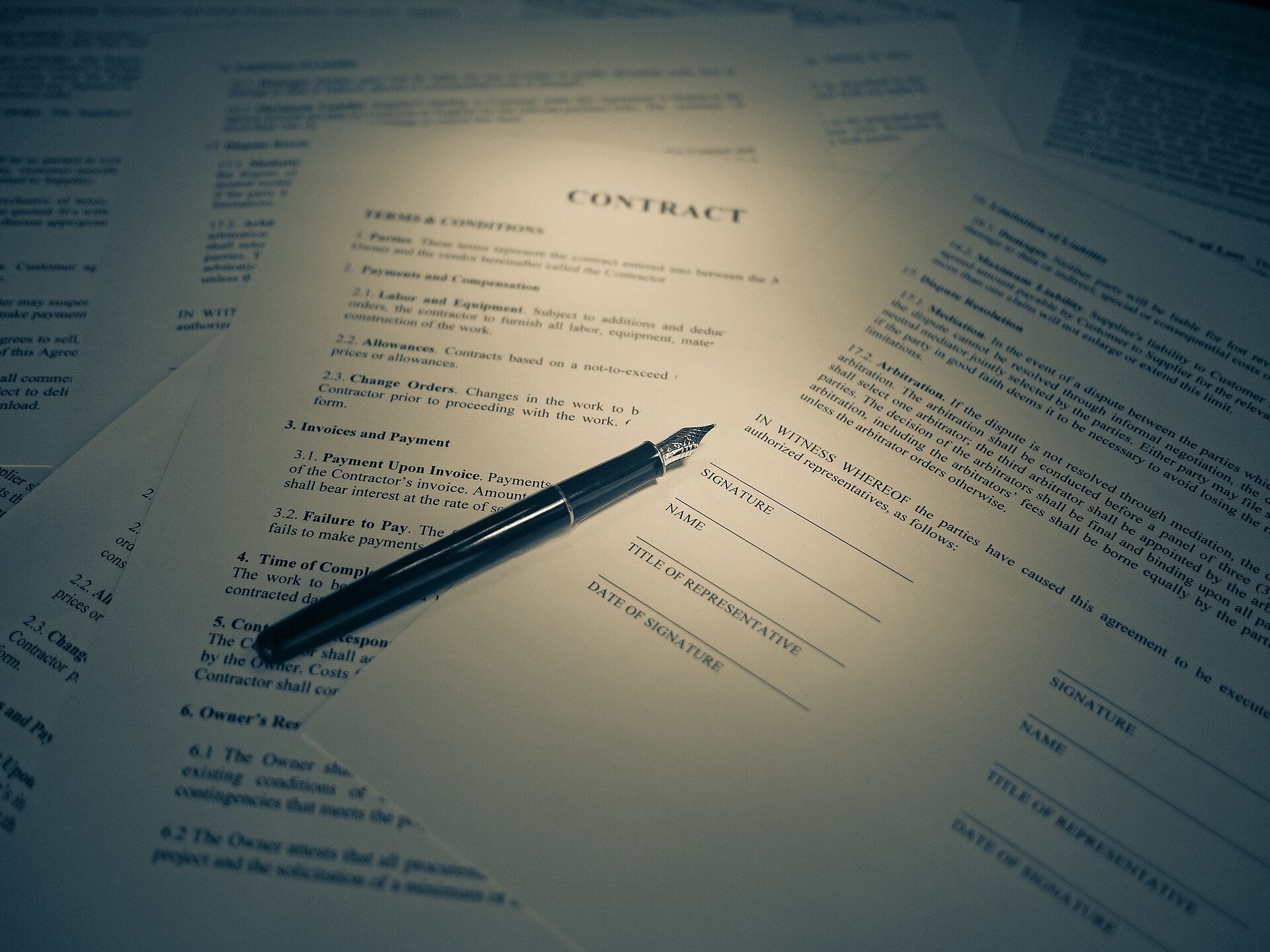 A printed contract document with a fountain pen